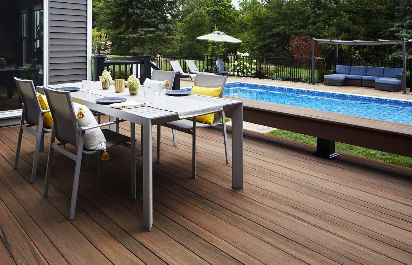 Deck with a dining table on it; deck built in TimberTech PVC decking, Vintage Collection in Mahogany