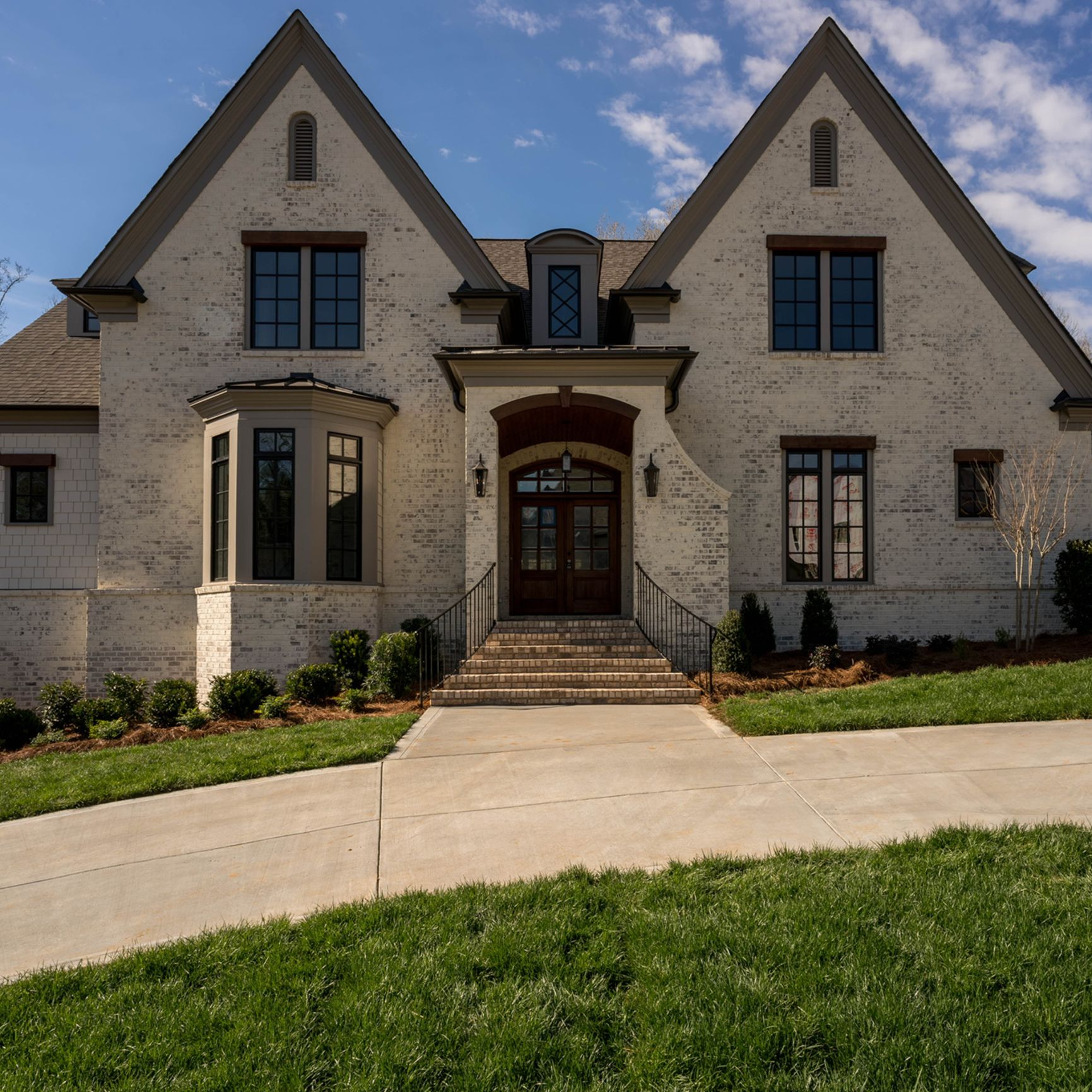 Riposo Beige brick home with dark wood accents