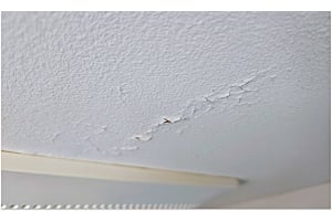 picture of flaking and cracking in a bathroom ceiling