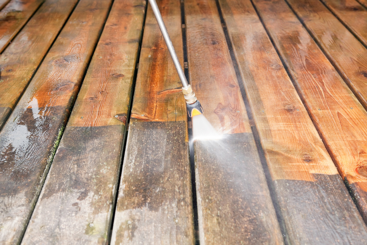 Real wood deck with mildew and discoloration being pressure washed