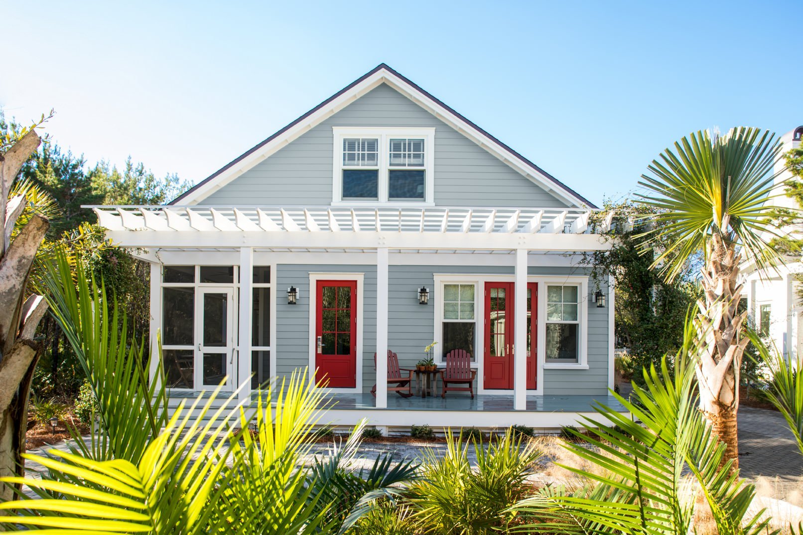 Home exterior with blue-gray siding painted in Nimbus Gray 2131-50 and porch painted in Normandy 2129-40, with front door in Benjamin Moore Caliente (AF-290)