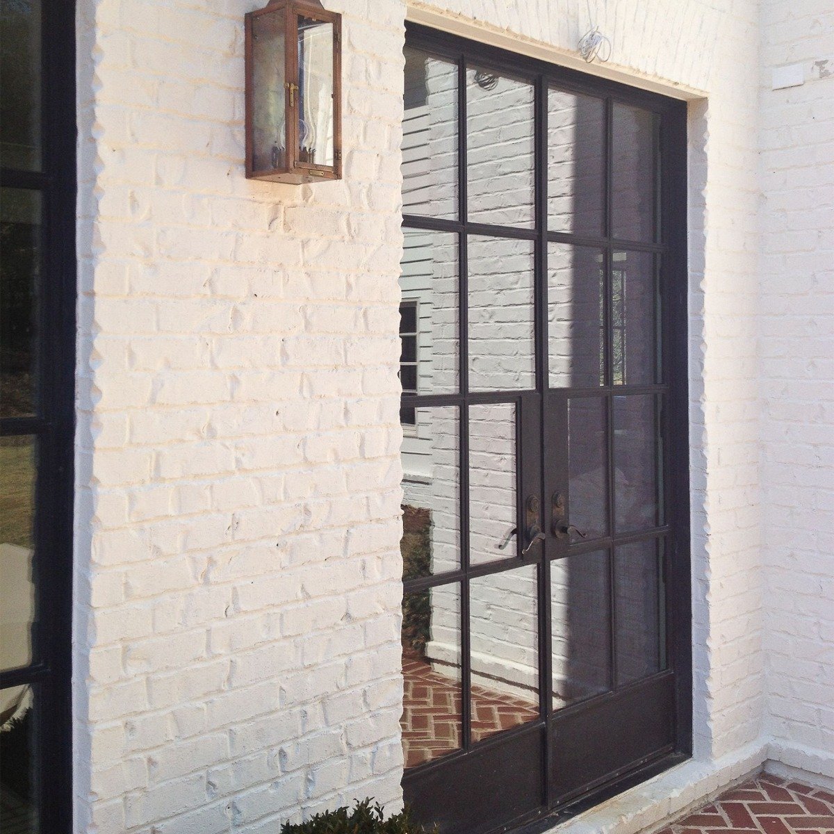 Brick house painted with white masonry paint